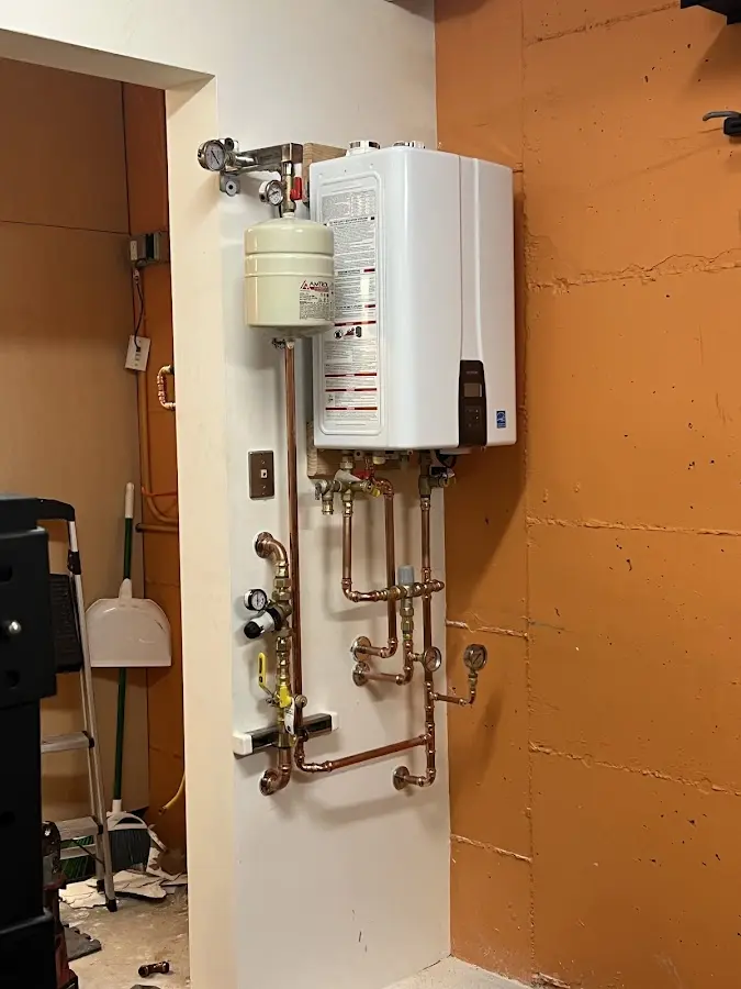 Plumbing technician inspecting water heater connections in Powell
